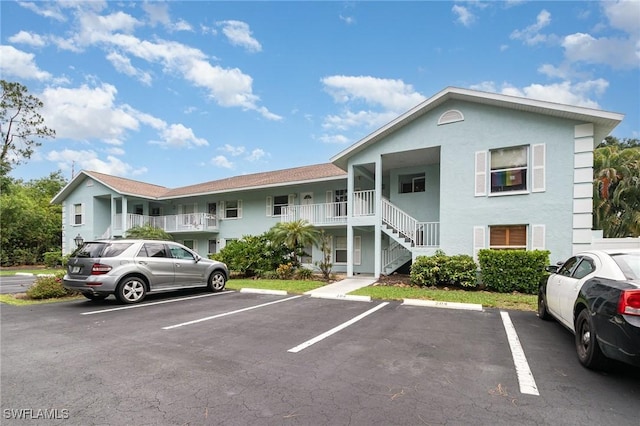 5737 Whitaker Rd Unit C203, Naples, FL 34112 - view of front of home featuring uncovered parking, stucco siding, and stairway