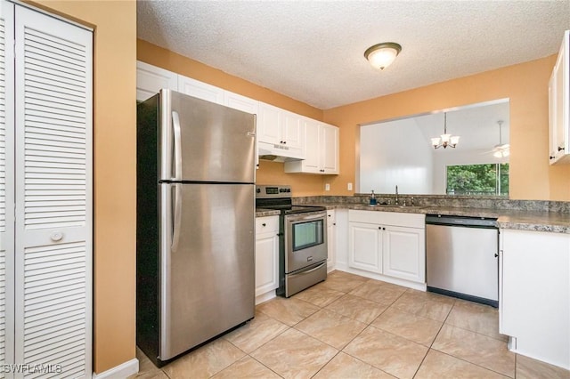5737 Whitaker Rd Unit C203, Naples, FL 34112 - kitchen featuring stainless steel appliances, under cabinet range hood, a sink, white cabinetry, and a chandelier