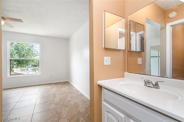 5737 Whitaker Rd Unit C203, Naples, FL 34112 - bathroom featuring a textured ceiling, vanity, ceiling fan, tile patterned floors, and baseboards