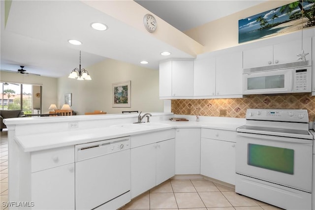 6810 Beach Resort Dr Unit 13, Naples, FL 34114 - kitchen featuring white appliances, a peninsula, a sink, light tile patterned floors, and backsplash