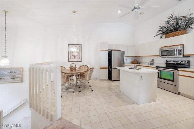 2141 Tama Cir Unit 202, Naples, FL 34112 - kitchen with appliances with stainless steel finishes, high vaulted ceiling, light countertops, a center island, and pendant lighting