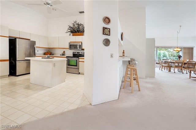 2141 Tama Cir Unit 202, Naples, FL 34112 - kitchen with high vaulted ceiling, appliances with stainless steel finishes, a kitchen island, light countertops, and ceiling fan