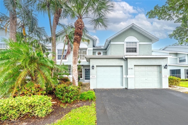 2141 Tama Cir Unit 202, Naples, FL 34112 - view of front facade featuring asphalt driveway, stucco siding, and a garage