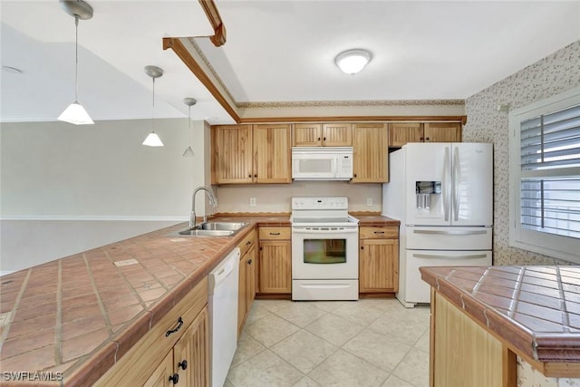 1051 Foxfire Ln Unit 309, Naples, FL 34104 - kitchen featuring white appliances, tile countertops, a sink, a peninsula, and wallpapered walls