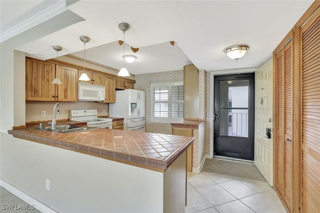 1051 Foxfire Ln Unit 309, Naples, FL 34104 - kitchen with white appliances, a sink, a peninsula, wallpapered walls, and light tile patterned flooring