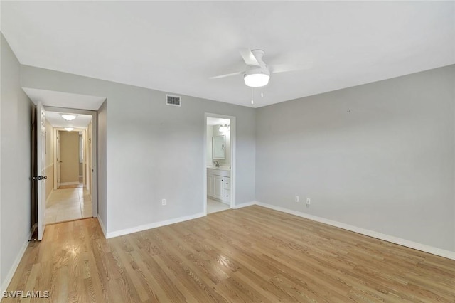 1051 Foxfire Ln Unit 309, Naples, FL 34104 - unfurnished bedroom with light wood-type flooring, baseboards, connected bathroom, and a ceiling fan