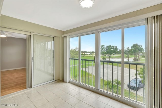 1051 Foxfire Ln Unit 309, Naples, FL 34104 - unfurnished sunroom featuring a water view, tile patterned flooring, ornamental molding, and baseboards