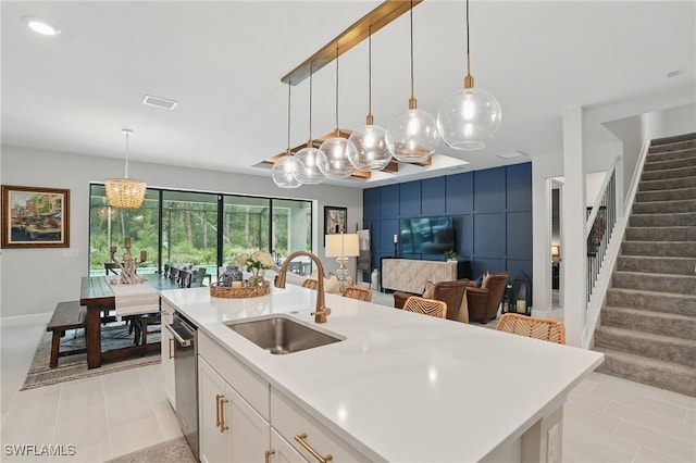 10415 Ventana Ln, Naples, FL 34120 - kitchen featuring light countertops, white cabinets, stainless steel dishwasher, an island with sink, and pendant lighting