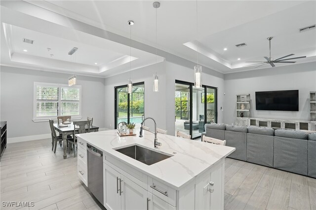 505 7th St NW, Naples, FL 34120 - kitchen featuring a tray ceiling, a sink, dishwasher, light stone counters, and hanging light fixtures