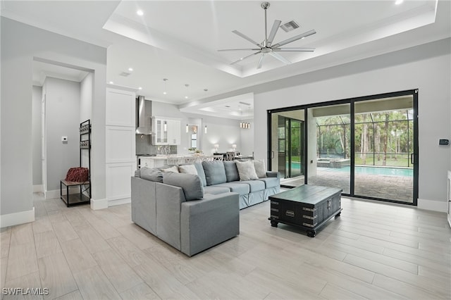 505 7th St NW, Naples, FL 34120 - living area featuring a raised ceiling, ceiling fan, recessed lighting, light wood finished floors, and ornamental molding