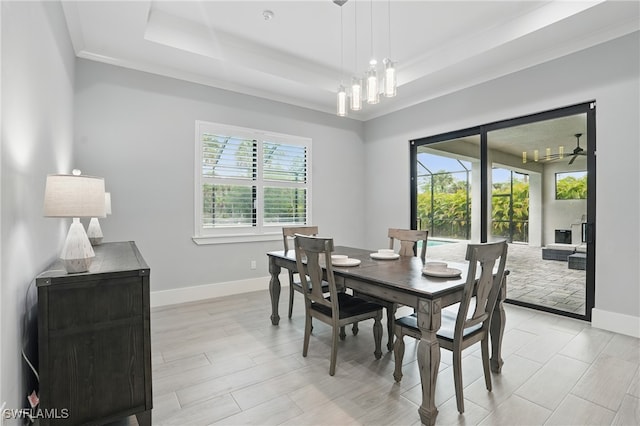 505 7th St NW, Naples, FL 34120 - dining area featuring a chandelier, a tray ceiling, baseboards, ornamental molding, and light wood-style floors