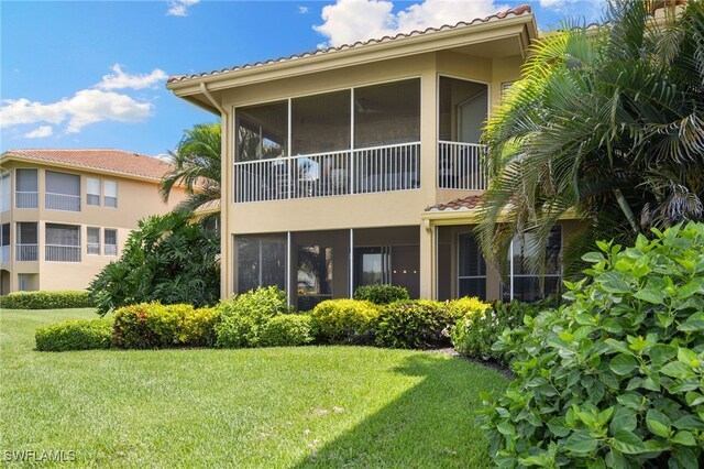 1880 Les Chateaux Blvd Unit 104, Naples, FL 34109 - rear view of property with a yard, a tiled roof, stucco siding, and a sunroom