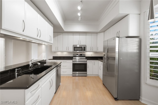 1880 Les Chateaux Blvd Unit 104, Naples, FL 34109 - kitchen with stainless steel appliances, dark countertops, rail lighting, light wood finished floors, and ornamental molding
