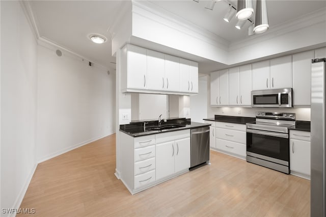 1880 Les Chateaux Blvd Unit 104, Naples, FL 34109 - kitchen featuring stainless steel appliances, dark countertops, ornamental molding, light wood finished floors, and white cabinets