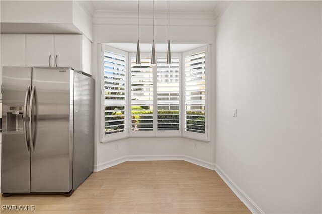 1880 Les Chateaux Blvd Unit 104, Naples, FL 34109 - kitchen featuring stainless steel refrigerator with ice dispenser, light wood-style floors, healthy amount of natural light, white cabinets, and ornamental molding