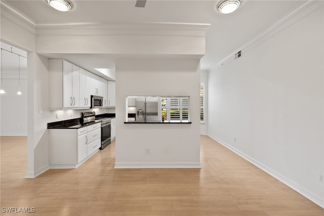 1880 Les Chateaux Blvd Unit 104, Naples, FL 34109 - kitchen with stainless steel appliances, dark countertops, white cabinets, crown molding, and light wood finished floors