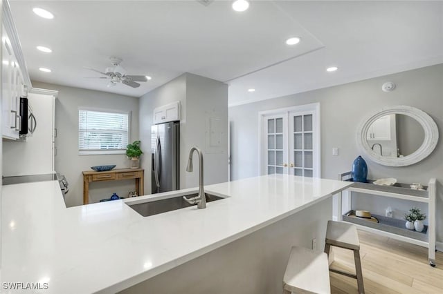 169 S Collier Blvd Unit H203, Marco Island, FL 34145 - kitchen featuring appliances with stainless steel finishes, light wood-style flooring, white cabinets, a peninsula, and recessed lighting