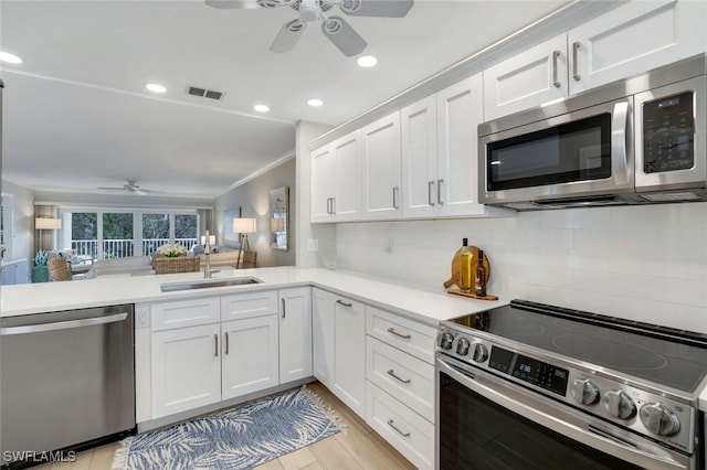 169 S Collier Blvd Unit H203, Marco Island, FL 34145 - kitchen with stainless steel appliances, a ceiling fan, light countertops, white cabinetry, and ornamental molding