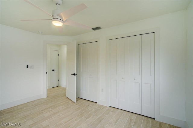 32 Fairview Blvd, Fort Myers Beach, FL 33931 - unfurnished bedroom with light wood-style flooring, two closets, ceiling fan, and baseboards