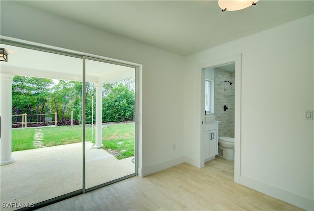 32 Fairview Blvd, Fort Myers Beach, FL 33931 - unfurnished bedroom featuring access to outside, light wood-style flooring, baseboards, and ensuite bathroom