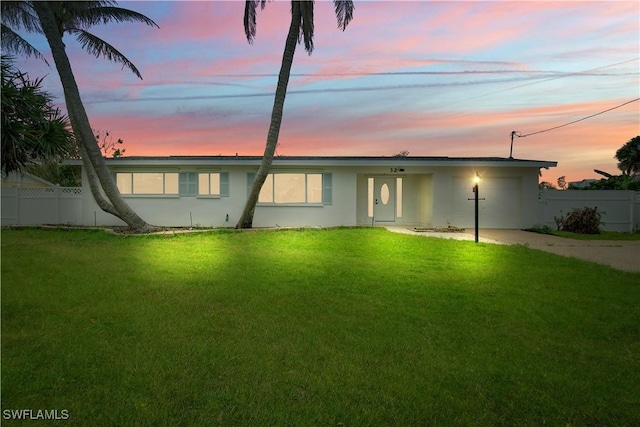 32 Fairview Blvd, Fort Myers Beach, FL 33931 - back of property at dusk with driveway, stucco siding, and a garage