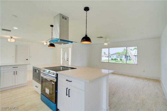 32 Fairview Blvd, Fort Myers Beach, FL 33931 - kitchen with stainless steel appliances, island range hood, light wood-style flooring, and light countertops