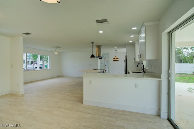 32 Fairview Blvd, Fort Myers Beach, FL 33931 - kitchen featuring healthy amount of natural light, fridge, wall chimney exhaust hood, light countertops, and recessed lighting