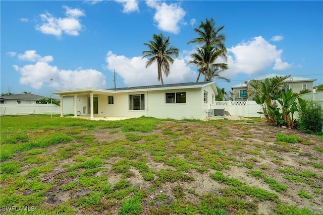 32 Fairview Blvd, Fort Myers Beach, FL 33931 - back of property with a patio area, central air condition unit, a fenced backyard, and stucco siding