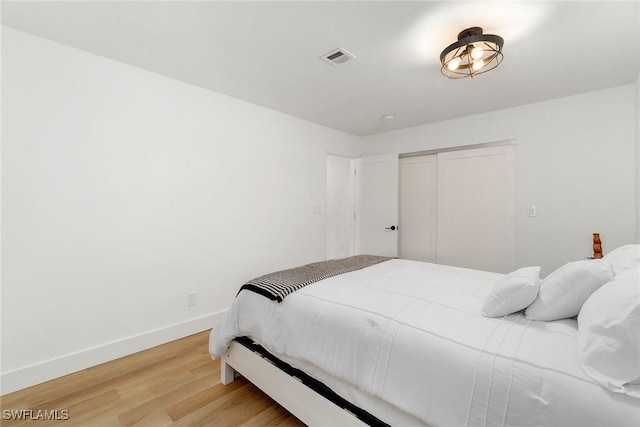 4126 Belair Ln Unit C6, Naples, FL 34103 - bedroom featuring light wood-style flooring, baseboards, and a closet