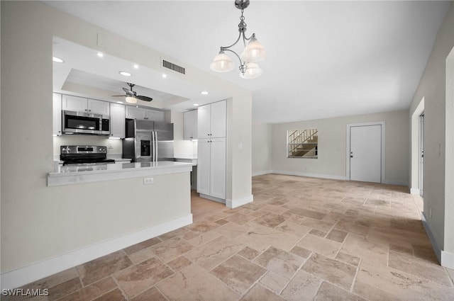 1549 Sandpiper St Unit 59, Naples, FL 34102 - kitchen with appliances with stainless steel finishes, stone tile flooring, baseboards, a tray ceiling, and light countertops