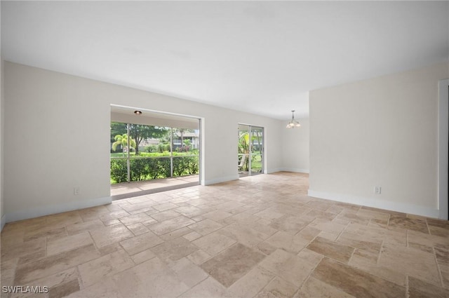1549 Sandpiper St Unit 59, Naples, FL 34102 - unfurnished room with stone tile flooring, a chandelier, and baseboards