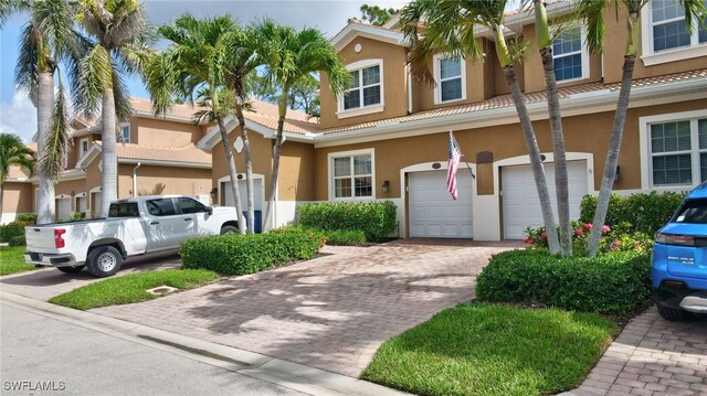 18273 Creekside Preserve Loop Unit 101, Fort Myers, FL 33908 - townhome / multi-family property with an attached garage, stucco siding, a tile roof, and driveway