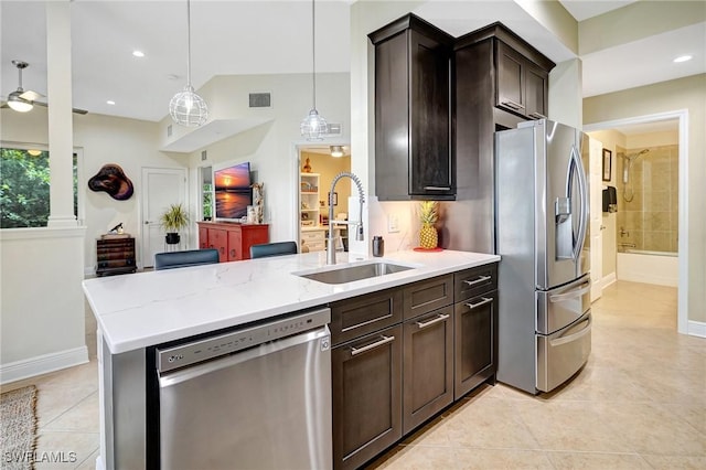 18273 Creekside Preserve Loop Unit 101, Fort Myers, FL 33908 - kitchen with stainless steel appliances, light tile patterned floors, dark brown cabinetry, light stone counters, and pendant lighting