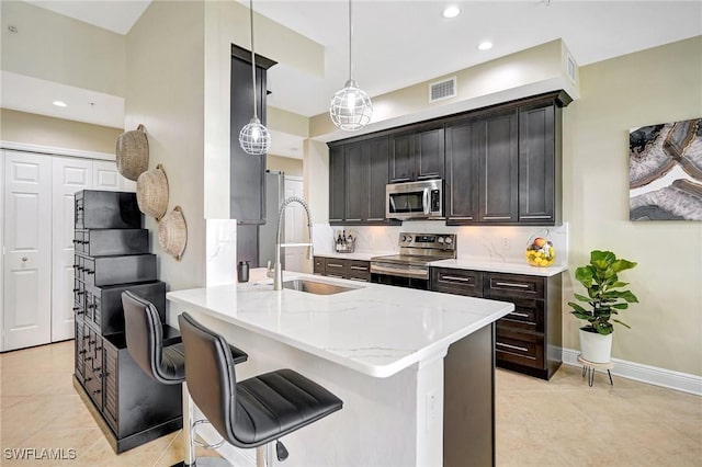 18273 Creekside Preserve Loop Unit 101, Fort Myers, FL 33908 - kitchen featuring appliances with stainless steel finishes, light tile patterned floors, a peninsula, light stone counters, and recessed lighting