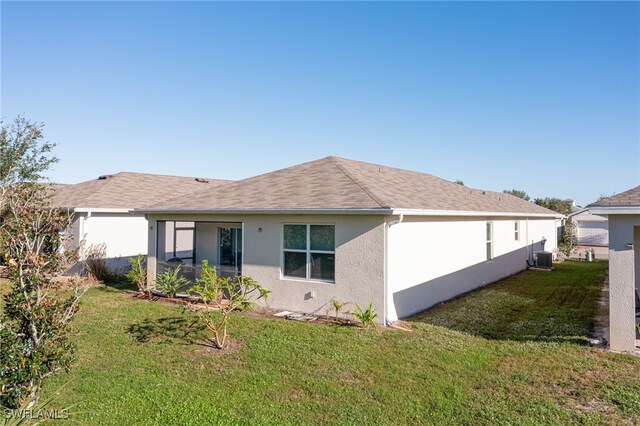 5213 Shell Mound Cir, Punta Gorda, FL 33982 - rear view of house featuring stucco siding, a lawn, and central AC unit