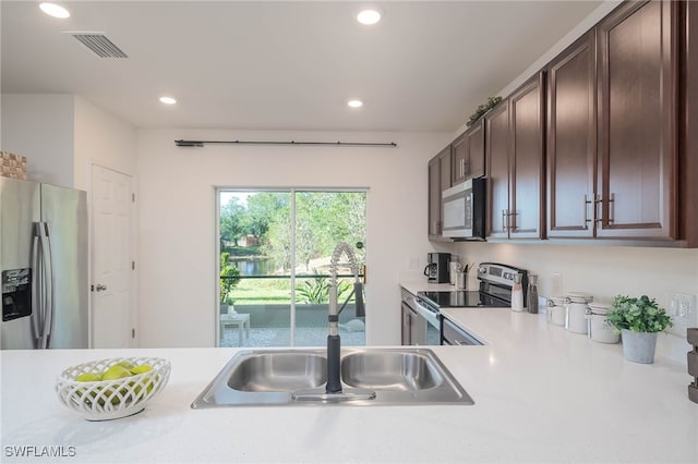 5213 Shell Mound Cir, Punta Gorda, FL 33982 - kitchen with appliances with stainless steel finishes, light countertops, a sink, dark brown cabinets, and recessed lighting