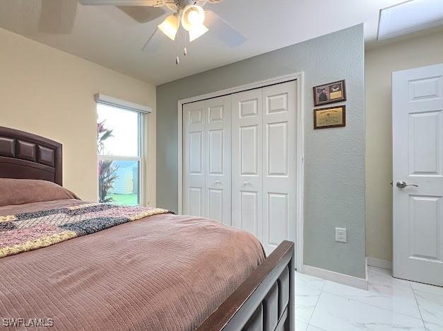 1220 Moore Run, Labelle, FL 33935 - bedroom with a closet, light marble finish floors, baseboards, and a ceiling fan