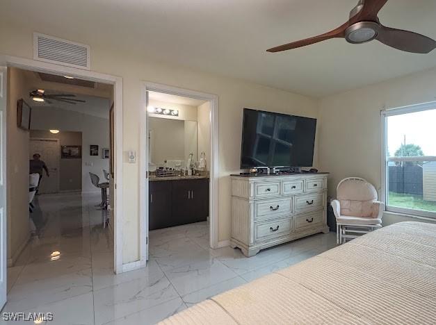 1220 Moore Run, Labelle, FL 33935 - bedroom featuring light marble finish floors, ensuite bath, and ceiling fan