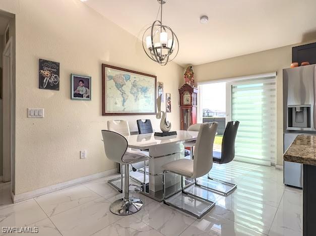 1220 Moore Run, Labelle, FL 33935 - dining room featuring light marble finish floors, a chandelier, and baseboards