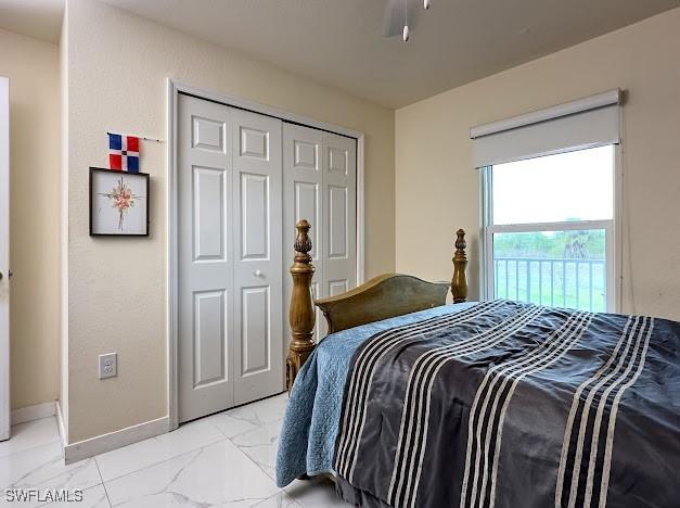 1220 Moore Run, Labelle, FL 33935 - bedroom with light marble finish floors, baseboards, and a closet