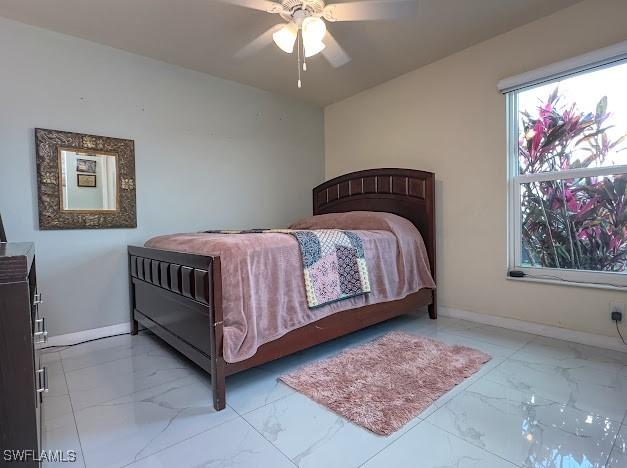 1220 Moore Run, Labelle, FL 33935 - bedroom featuring marble look tile flooring, baseboards, and ceiling fan
