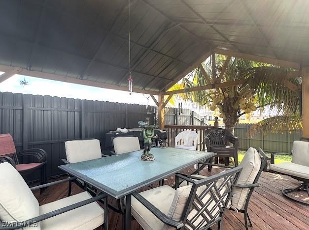 1220 Moore Run, Labelle, FL 33935 - wooden deck with outdoor dining space, a fenced backyard, and a gazebo