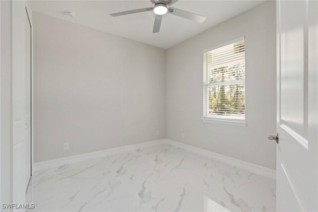 1404 W 12th St, Lehigh Acres, FL 33972 - spare room featuring marble look tiles, a ceiling fan, a smoke detector, and baseboards