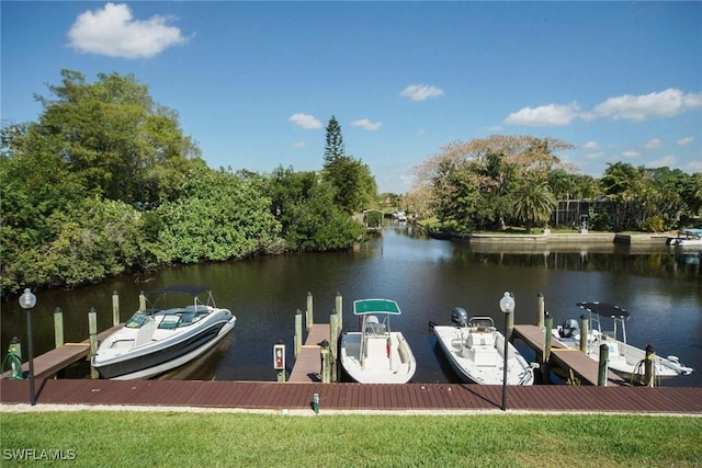 13460 Wild Cotton Ct, North Fort Myers, FL 33903 - dock featuring a water view, boat lift, and view of scattered trees
