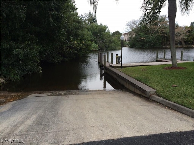 13460 Wild Cotton Ct, North Fort Myers, FL 33903 - dock area with a boat ramp, a water view, and a yard