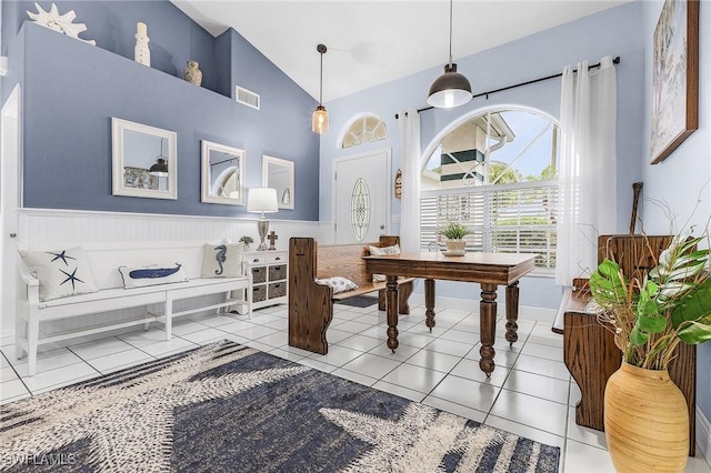13460 Wild Cotton Ct, North Fort Myers, FL 33903 - dining room with wainscoting, light tile patterned flooring, and high vaulted ceiling