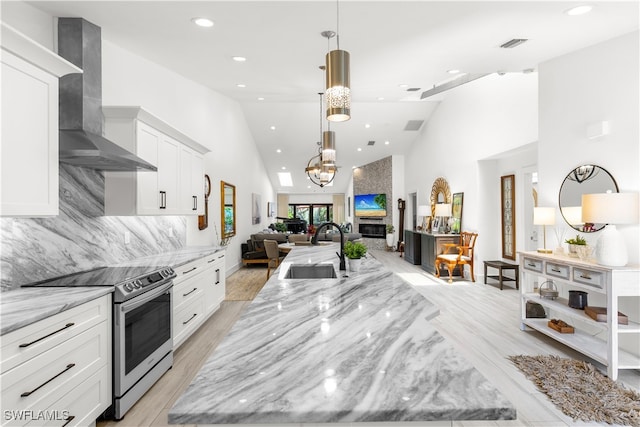 4014 Crayton Rd Unit B4, Naples, FL 34103 - kitchen with wall chimney range hood, electric range, a sink, open floor plan, and high vaulted ceiling