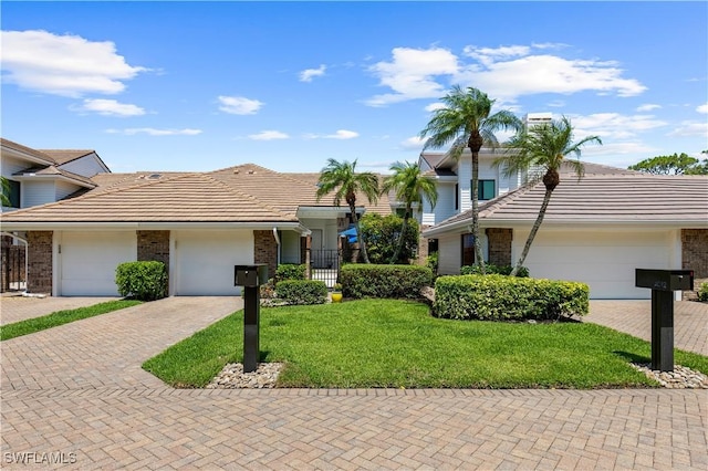 4014 Crayton Rd Unit B4, Naples, FL 34103 - view of front of property featuring a tile roof, decorative driveway, brick siding, and a front lawn