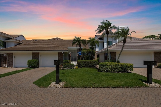 4014 Crayton Rd Unit B4, Naples, FL 34103 - view of front facade featuring a tile roof, an attached garage, decorative driveway, and a front yard