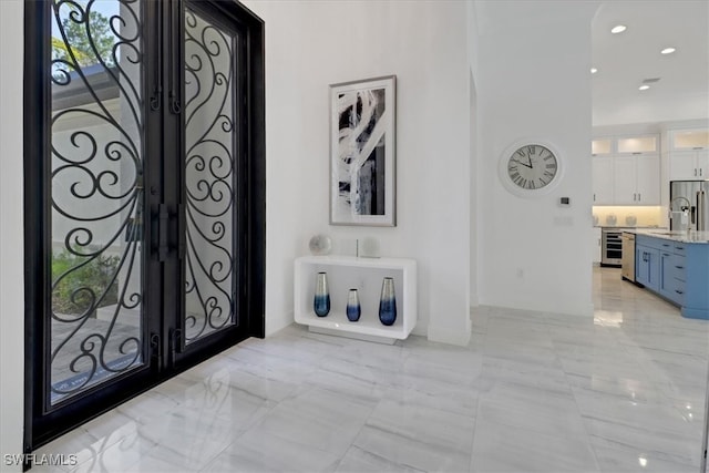 4472 Pine Ridge Rd, Naples, FL 34119 - entryway with light marble finish flooring, beverage cooler, recessed lighting, and french doors